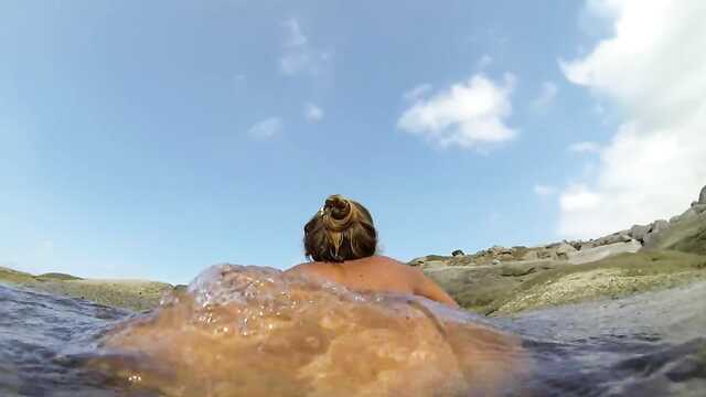 Женщина оголила сиси купаясь в море